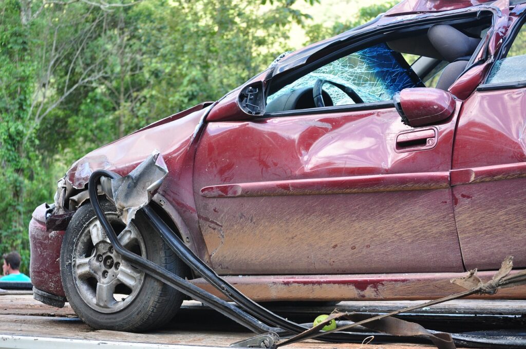 Road traffic accident liability illustrated by a severely damaged red car after a serious collision.