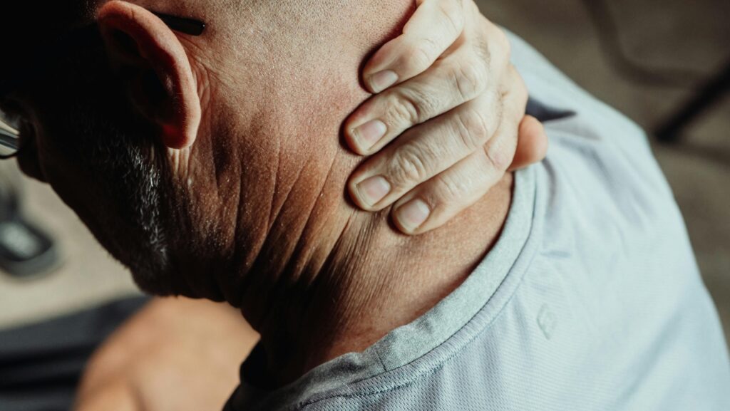 Man suffering neck pain after accident, considering whiplash claim payout options.