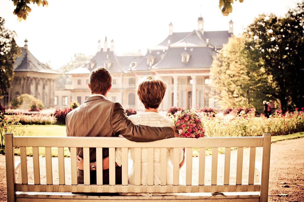 Married couple sitting on bench after ceremony – Scotland marriage age context