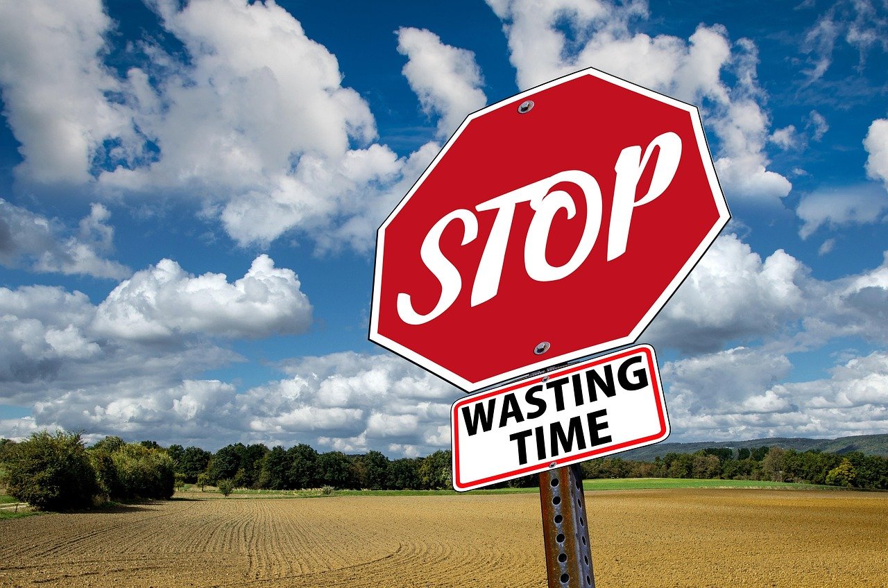 A red stop sign reading “Stop Wasting Time” against a blue sky, illustrating urgency under the limitation period UK rules.